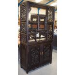 A LARGE 19TH CENTURY CHINESE HONGMU DISPLAY CABINET Qing, overlaid with foliage and trailing vines.