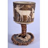 A 19TH CENTURY BAVARIAN BLACK FOREST CARVED IVORY AND HORN CUP decorated with hunting scenes. 10 cm