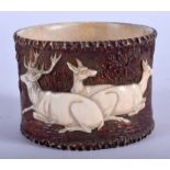 A 19TH CENTURY BAVARIAN BLACK FOREST CARVED IVORY AND HORN NAPKIN RING decorated with animals. 7 cm