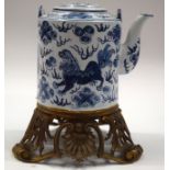 A CHINESE BLUE AND WHITE TEAPOT upon a bronze stand. 28 cm high.