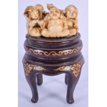 A 19TH CENTURY JAPANESE MEIJI PERIOD CARVED IVORY NETSUKE OKIMONO upon an associated stand, modelled
