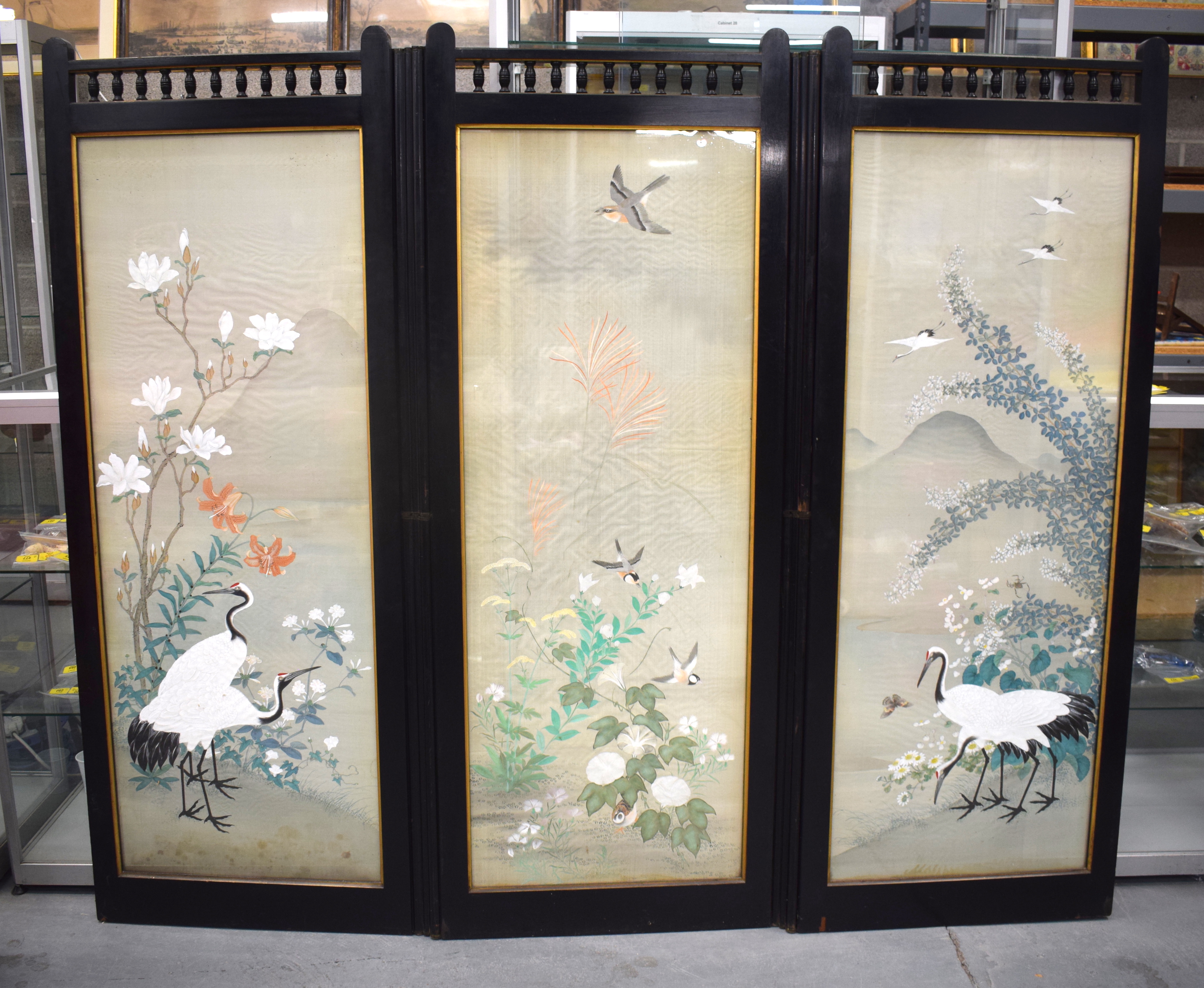 A 19TH CENTURY JAPANESE MEIJI PERIOD THREE PANEL SILKWORK SCREEN painted with birds within a landsca