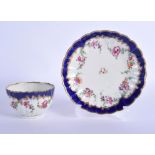 AN 18TH CENTURY WORCESTER FLUTED TEABOWL AND SAUCER painted with flowers on a blue ground. Saucer 12