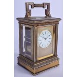 AN ANTIQUE FRENCH BRASS REPEATING CARRIAGE CLOCK with engine turned faceplate. 18 cm high handle.