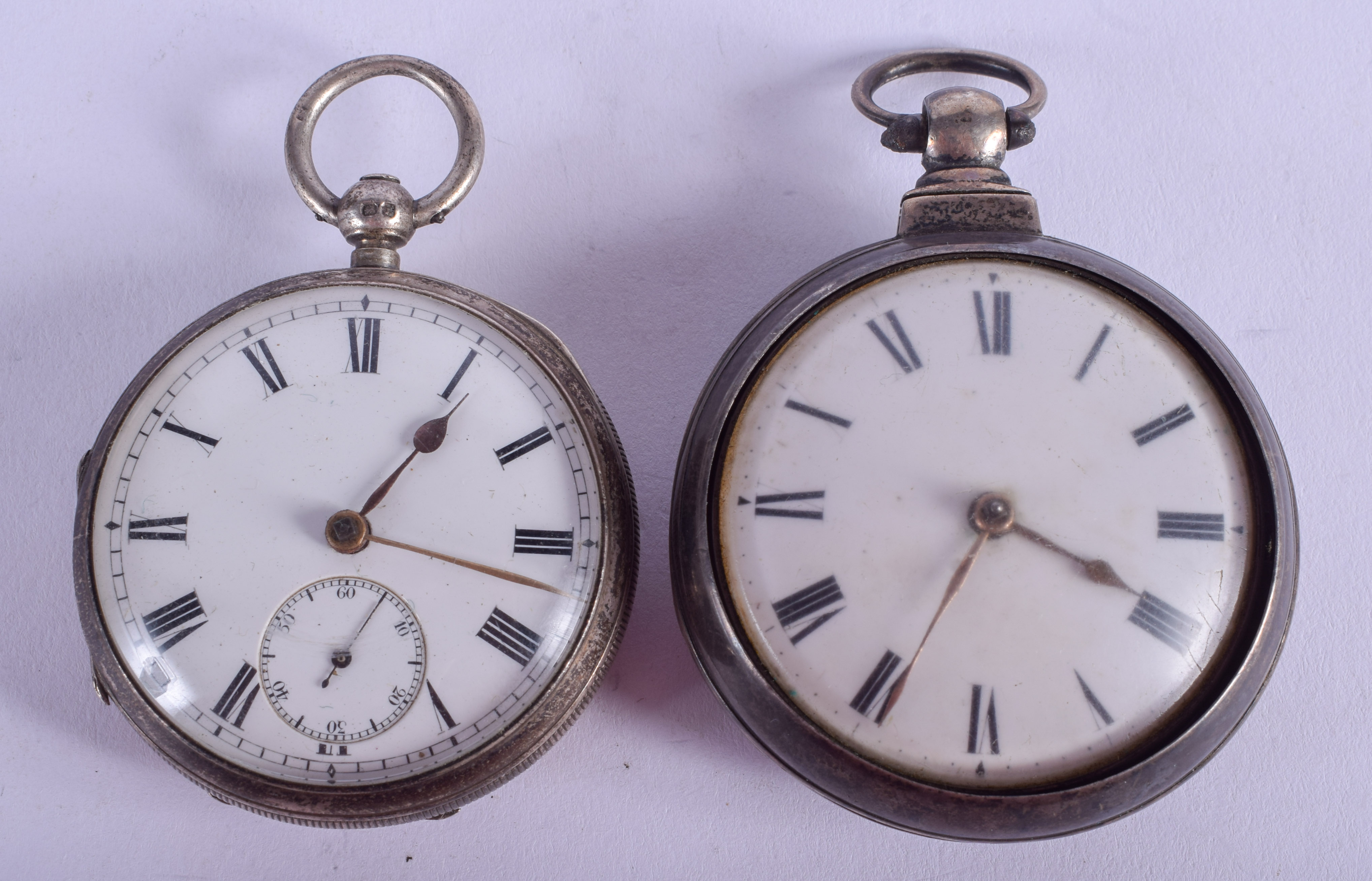 A GEORGE III PAIR CASED SILVER POCKET WATCH together with another. 5.5 cm wide. (2)