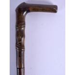 A 19TH CENTURY CARVED RHINOCEROS HORN HANDLED WALKING CANE with bamboo shaft. 80 cm long.