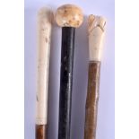 A 19TH CENTURY CONTINENTAL CARVED IVORY HANDLED WALKING CANE together with two other antique ivory c