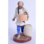 A CHARMING ANTIQUE RUSSIAN GARDNER BISQUE PORCELAIN FIGURE OF A PEASANT modelled roaming throwing gr