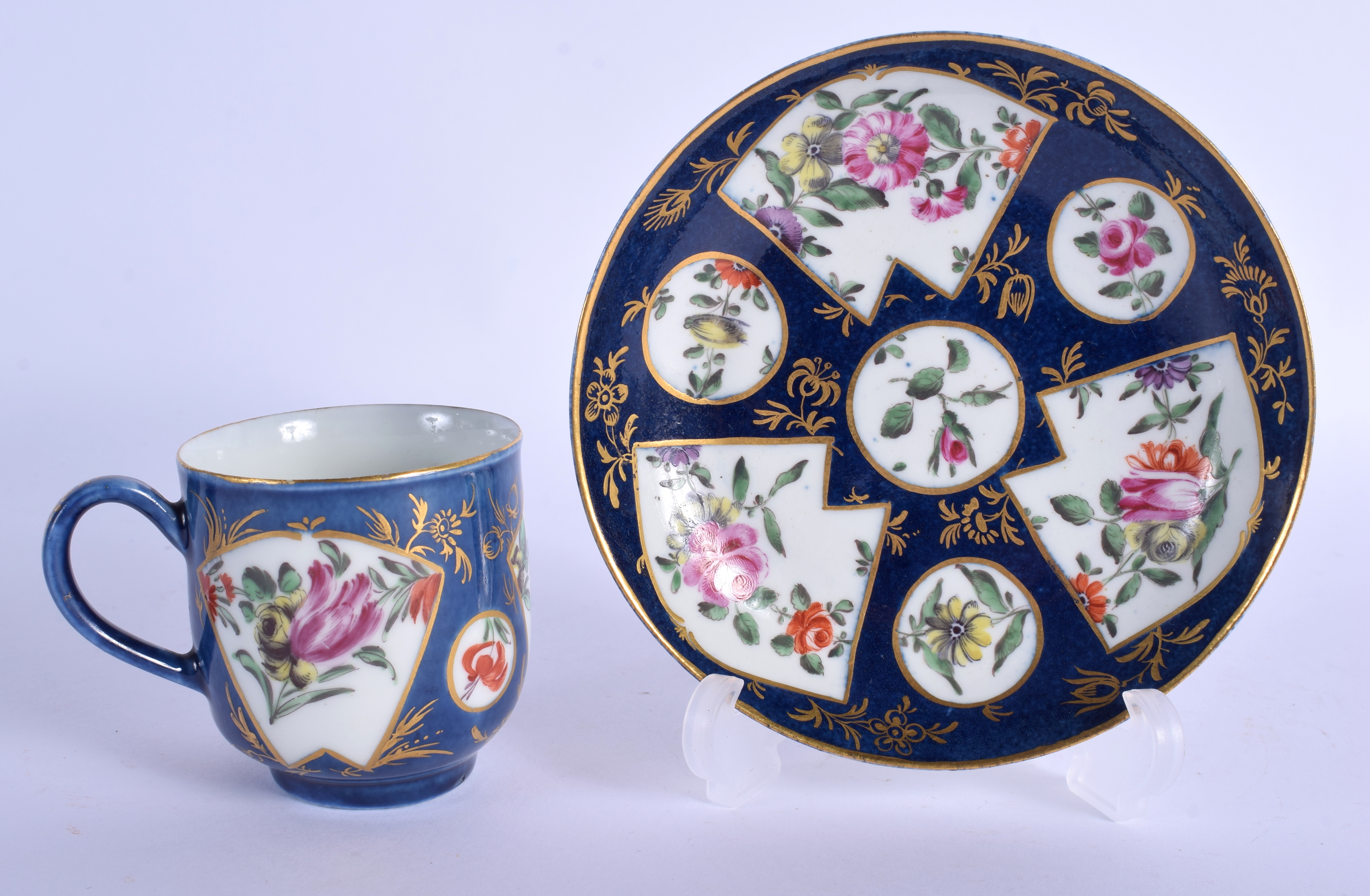 A FINE 18TH CENTURY WORCESTER COFFEE CUP AND SAUCER painted with flowers on a blue fan ground. Sauce