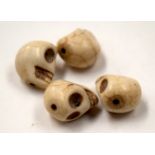 FOUR ASIAN STONE SKULL BEADS. (4)