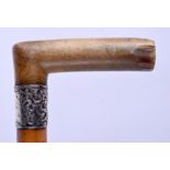 A 19TH CENTURY CARVED RHINOCEROS HORN HANDLED WALKING CANE with silver mounts. 86 cm long.