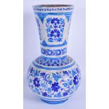 AN ISLAMIC MIDDLE EASTERN FAIENCE VASE painted with flowers. 32 cm high.