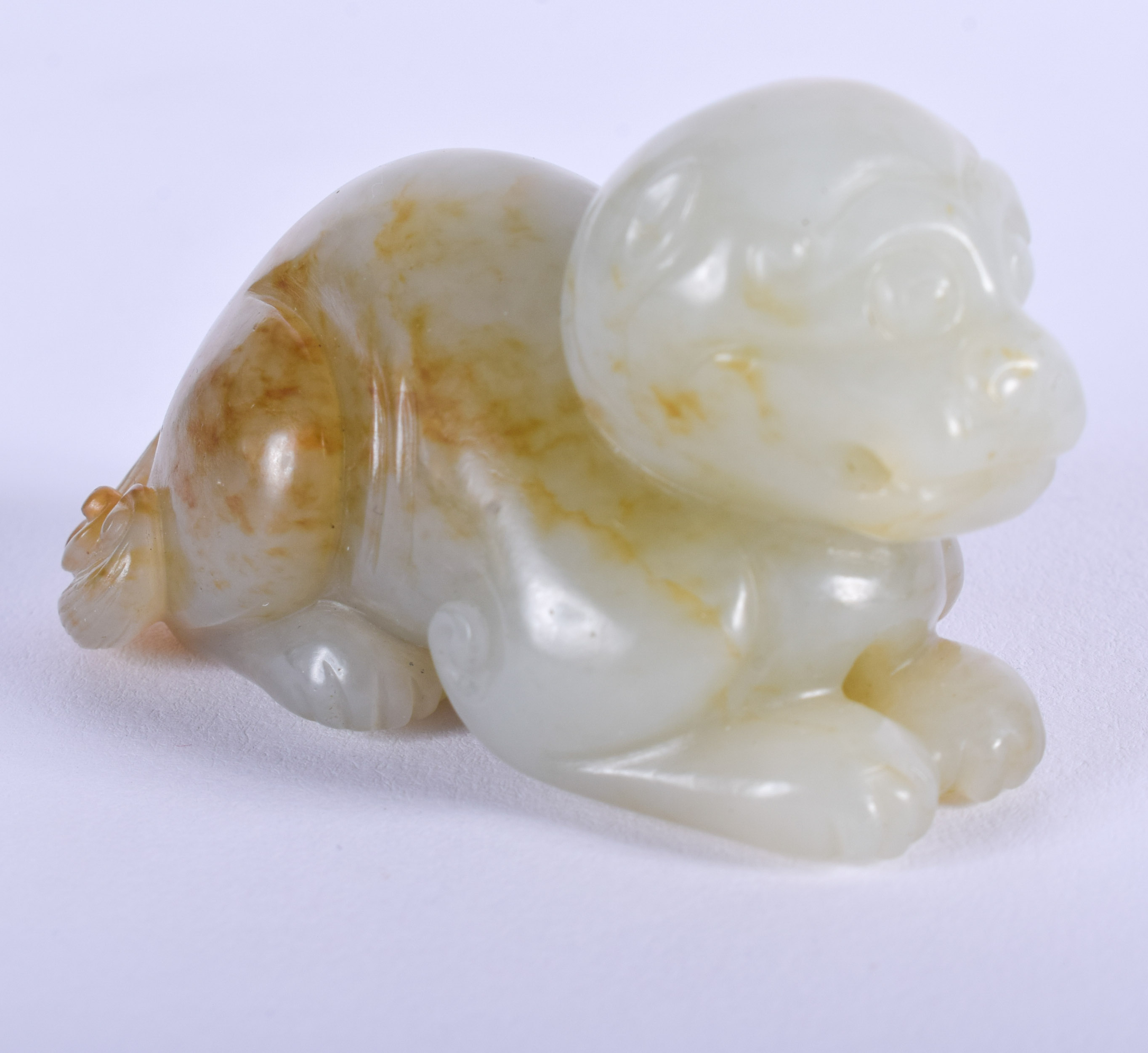 A 19TH CENTURY CHINESE CARVED GREENISH WHITE JADE BEAST Qing, with russet inclusions. 5.5 cm wide.
