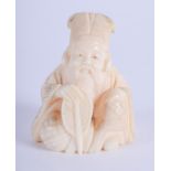 A 19TH CENTURY JAPANESE MEIJI PERIOD CARVED IVORY OKIMONO modelled as a seated male. 4 cm x 3.25 cm.