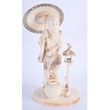A 19TH CENTURY JAPANESE MEIJI PERIOD CARVED IVORY OKIMONO modelled holding a parasol beside a bird c