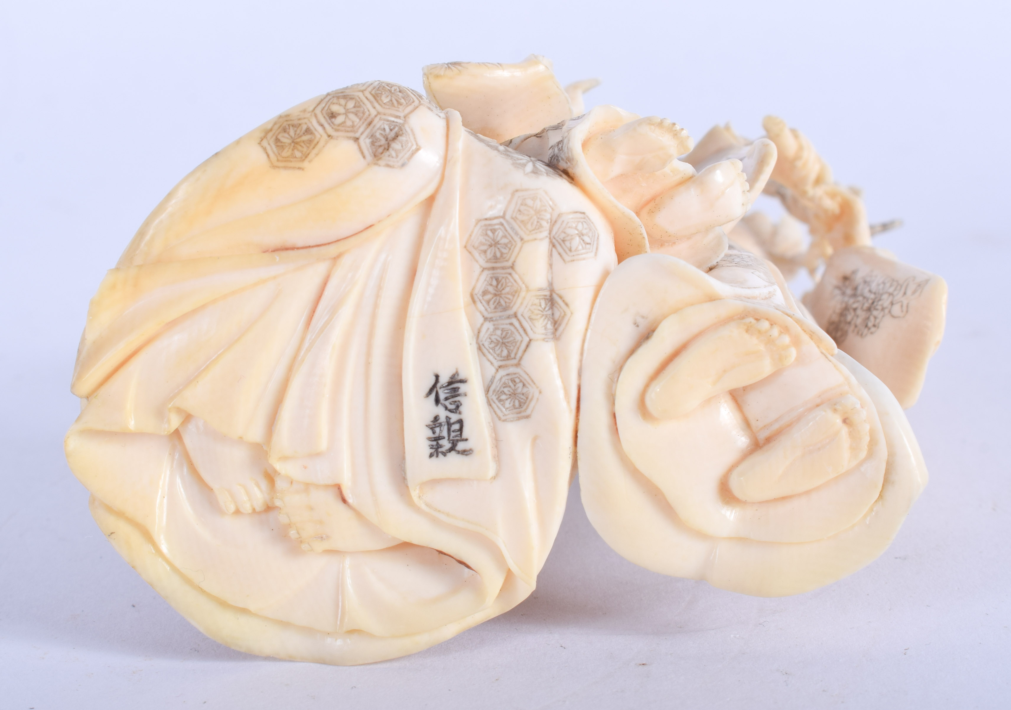 A FINE 19TH CENTURY JAPANESE MEIJI PERIOD CARVED IVORY OKIMONO modelled with geisha holding foliage. - Image 4 of 4