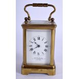 A MINIATURE ANTIQUE FRENCH BRASS CARRIAGE CLOCK retailed by Searle & Co London. 10 cm high inc handl