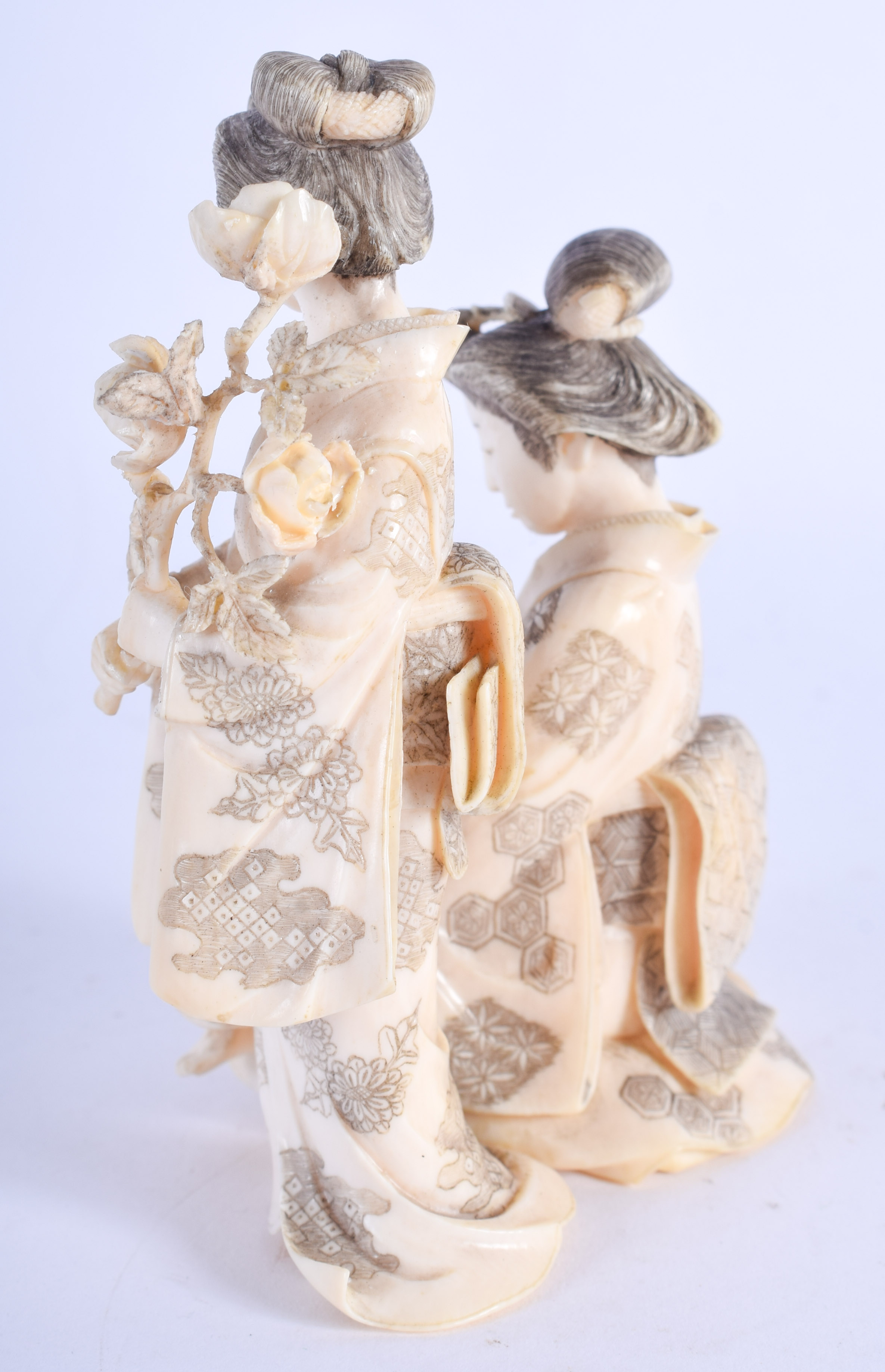 A FINE 19TH CENTURY JAPANESE MEIJI PERIOD CARVED IVORY OKIMONO modelled with geisha holding foliage. - Image 2 of 4