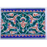 A MIDDLE EASTERN TURKISH IZNIK POTTERY TILE painted with scrolling foliage. 16 cm x 24 cm.