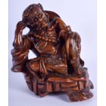 A 19TH CENTURY CHINESE CARVED ROOTWOOD FIGURE A BUDDHA modelled resting upon his arm. 19 cm x 12 cm.