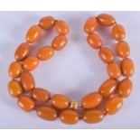 A 1920S SILVER AND AMBER NECKLACE. 100 grams. 62 cm long. Largest bead 2.25 cm wide.