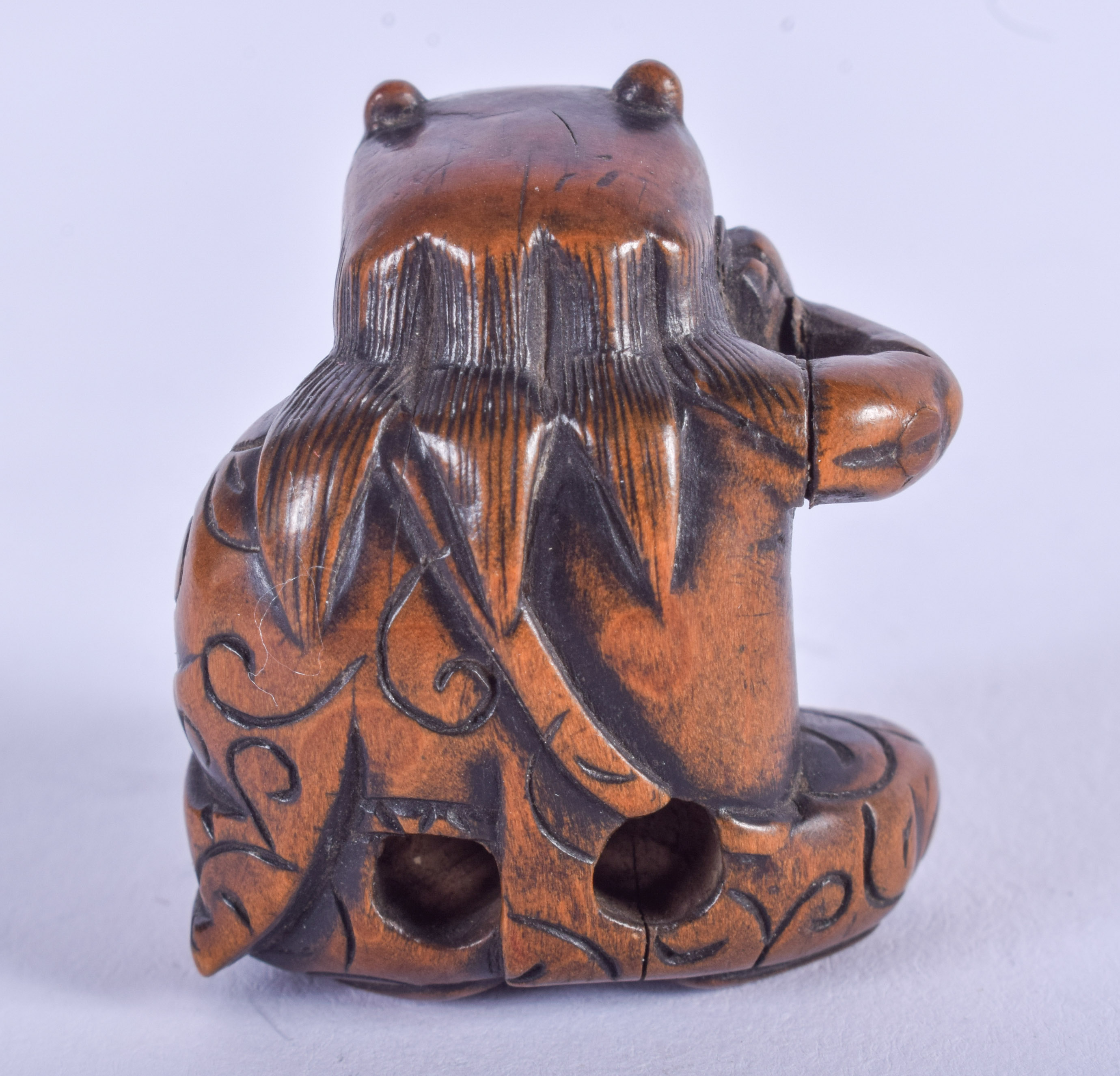 A 19TH CENTURY JAPANESE MEIJI PERIOD CARVED BOXWOOD NETSUKE modelled as a seated oni holding his che - Image 2 of 3