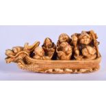 A 19TH CENTURY JAPANESE MEIJI PERIOD CARVED IVORY NETSUKE modelled with figures upon a dragon boat.