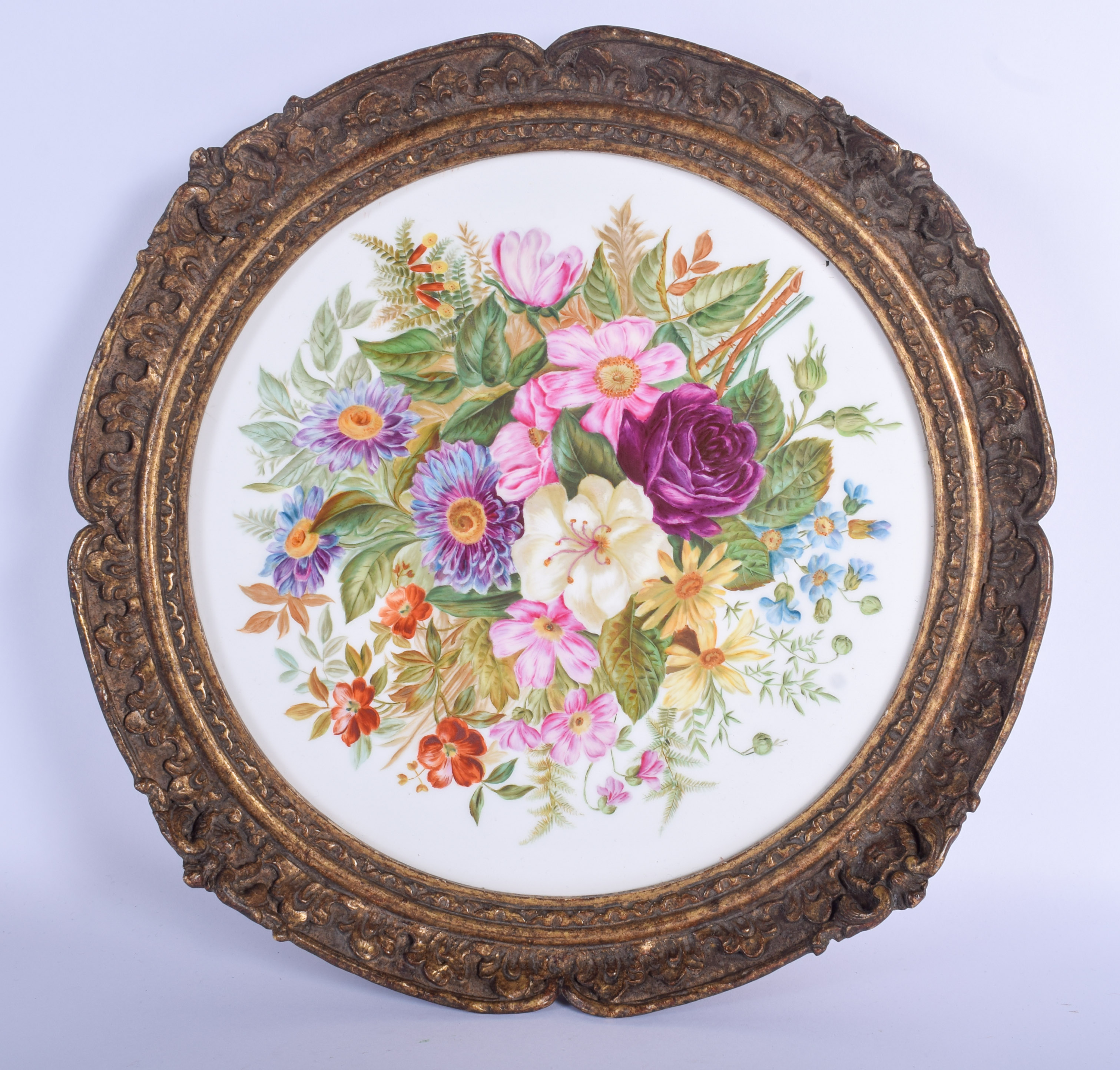A superb early 19th c. English porcelain plaque lavishly painted with flowers in a circular gilded f