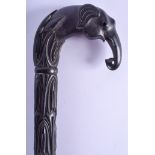 A 19TH CENTURY SRI LANKAN CARVED EBONY WALKING CANE formed with an elephant upon an acanthus capped