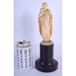 A 19TH CENTURY EUROPEAN CARVED BONE FIGURE OF A SAINT AND CHILD modelled upon an ebonised base. Ivo