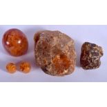 TWO AMBER BOULDERS together with three beads. 95.4 grams. (5)