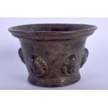 A 17TH/18TH CENTURY CONTINENTAL BRONZE MORTAR decorated with mask heads. 10.5 cm wide.