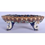 A 19TH CENTURY CONTINENTAL MAJOLICA OVAL COMPORT formed with figures holding aloft a basket with dis