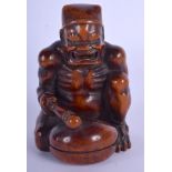 A 19TH CENTURY JAPANESE MEIJI PEIROD CARVED BOXWOOD OKIMONO modelled as a seated oni beating a drum.