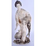 A FINE 19TH CENTURY JAPANESE MEIJI PERIOD CARVED IVORY OKIMONO modelled as a female holding rearing