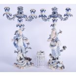 A LARGE PAIR OF 19TH CENTURY MEISSEN PORCELAIN CANDLESTICKS modelled as a male and female upon a roc