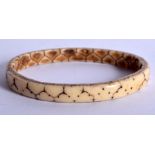 AN ANTIQUE TRIBAL CARVED BANGLE. 6.5 cm wide.