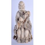 A 19TH CENTURY CHINESE CARVED BONE FIGURE OF SAGE modelled holding a peach beside a bird. 18 cm high