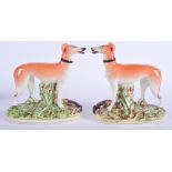 A PAIR OF 19TH CENTURY STAFFORDSHIRE FIGURES OF GREYHOUNDS. 16 cm x 21 cm.