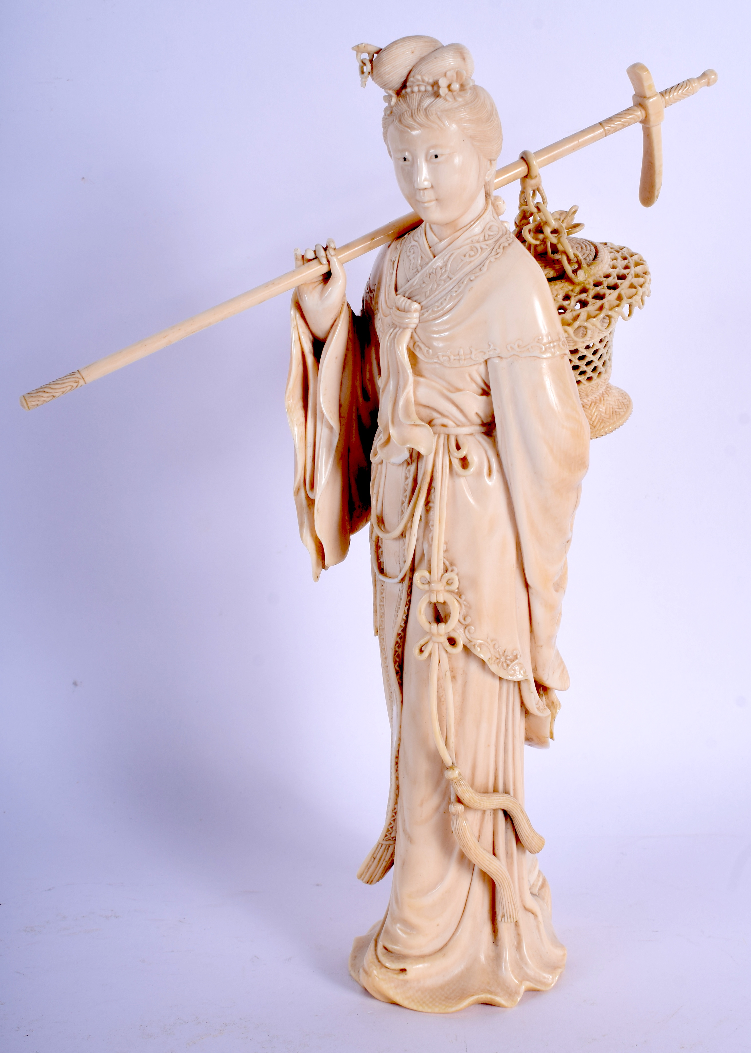 A 19TH CENTURY CHINESE CARVED BONE FIGURE OF A FEMALE modelled holding a basket in flowing robes. 2