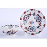 AN 18TH CENTURY LIVERPOOL JOHN PENNINGTON TEA BOWL AND SAUCER painted with red and blue floral deco