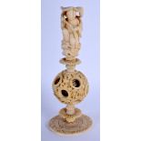 A 19TH CENTURY CHINESE CARVED BONE PUZZLE BALL formed as a male holding a lotus. 16 cm high.
