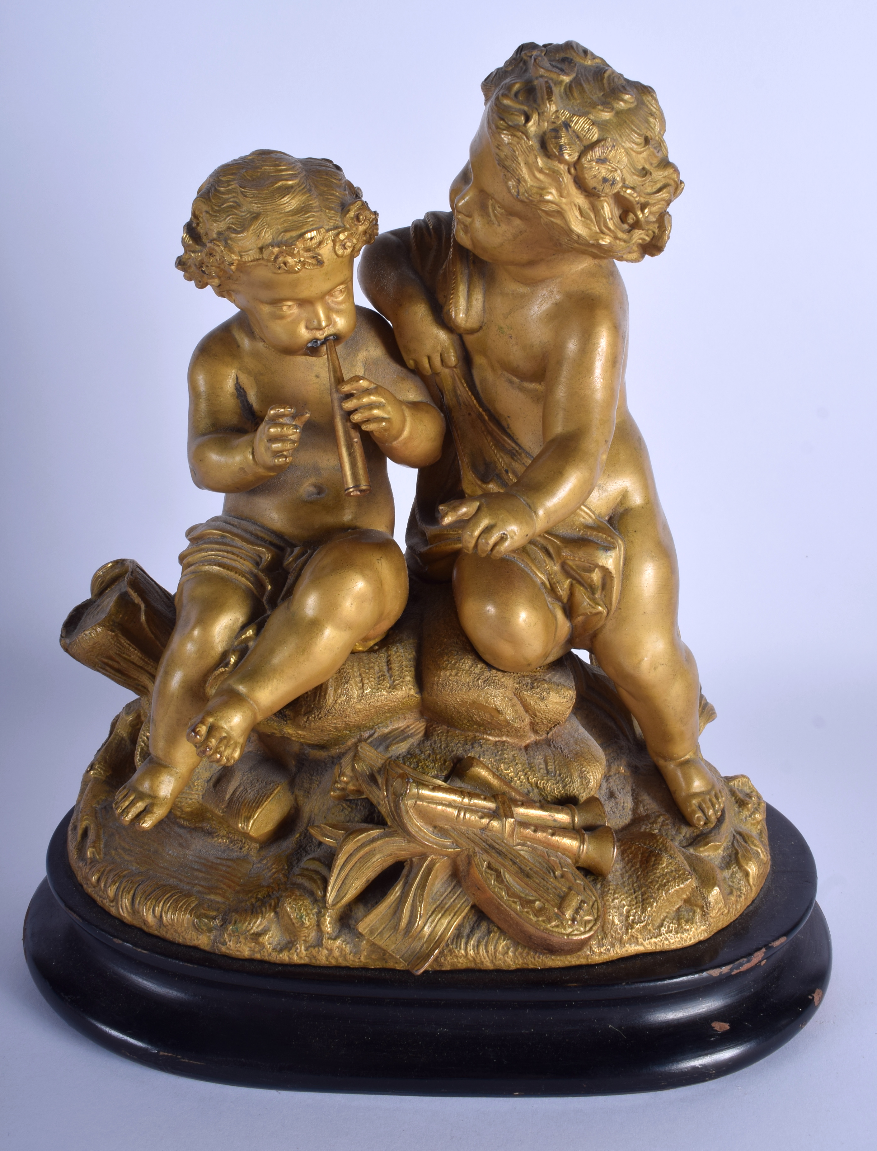 A 19TH CENTURY FRENCH GILDED SPELTER FIGURE OF TWO PUTTI modelled upon am eboinsed base. 21 cm x 27