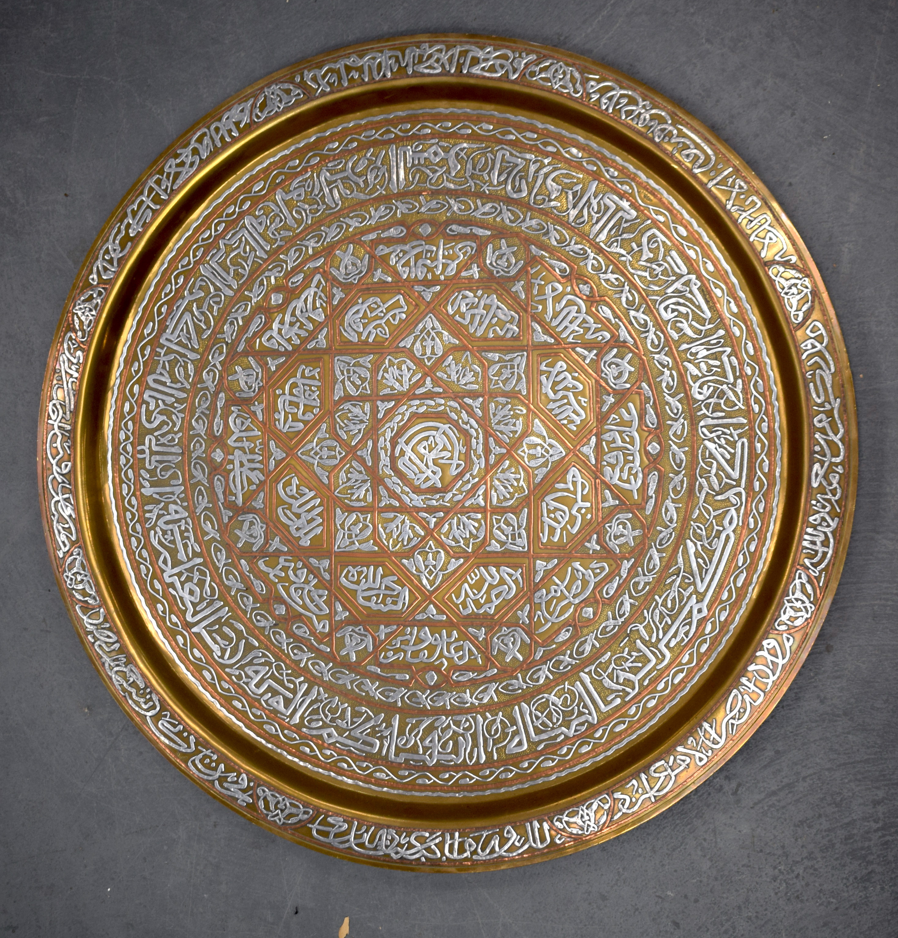 A LARGE MIDDLE EASTERN SILVER INLAID CAIROWARE STYLE CHARGER. 69 cm diameter.