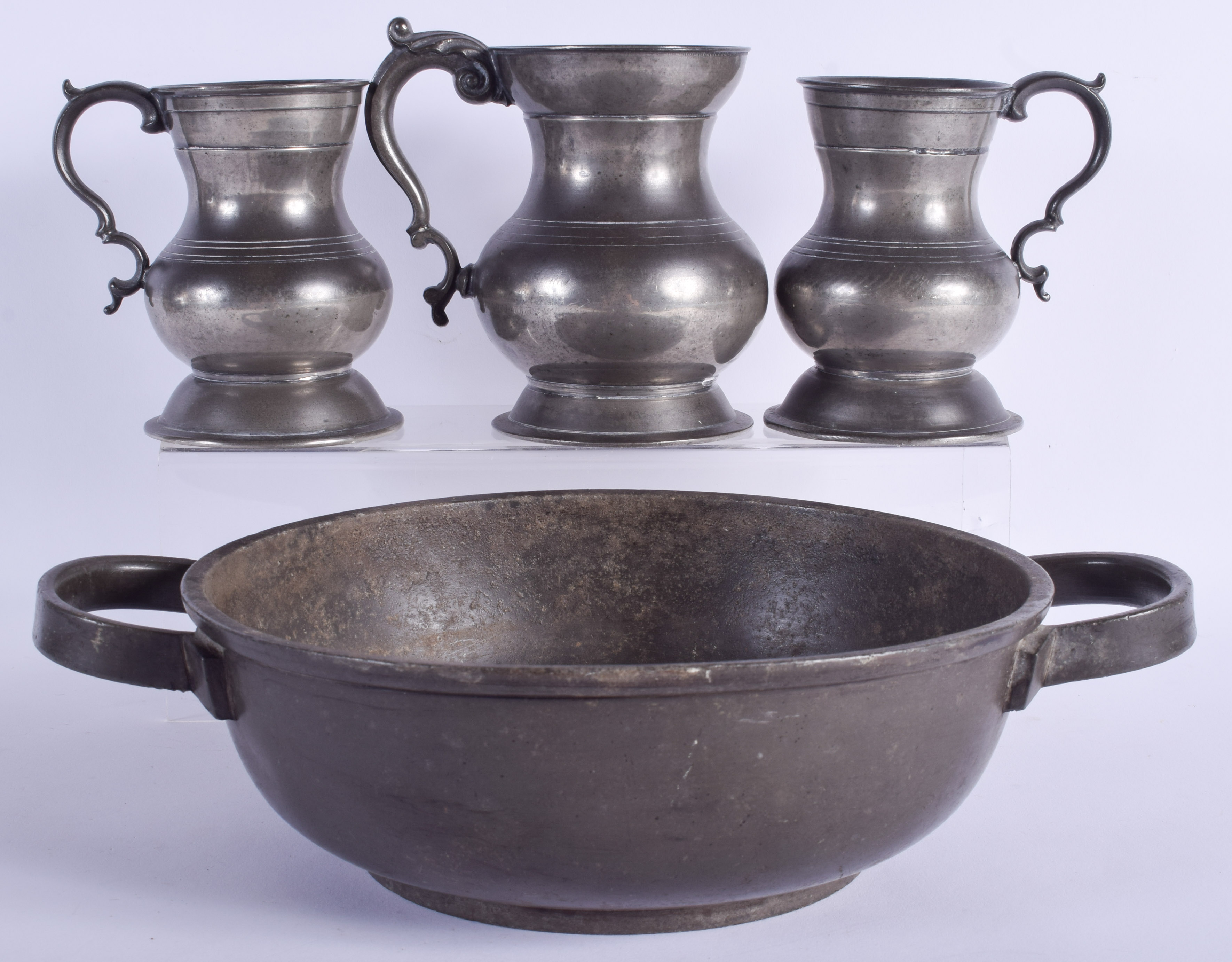 THREE ANTIQUE LONDON PEWTER MUGS together with a basin. Largest 31 cm wide. (4)