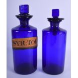 A PAIR OF VINTAGE BLUE GLASS MEDICINE BOTTLES AND STOPPERS. Largest 26 cm high. (2)