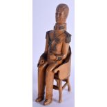 A 19TH CENTURY FRENCH TREEN CARVED FRUITWOOD FIGURE OF A MILITARY MALE modelled seated upon a chair.