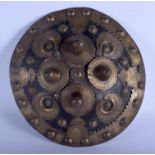 A MIDDLE EASTERN BRASS MOUNTED TARGE SHIELD decorated with motifs. 24 cm diameter.