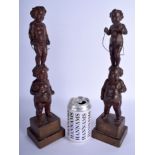 A PAIR OF 19TH CENTURY CONTINENTAL CARVED WOOD FIGURES OF CHERUBS modelled upon stepped bases. 35 cm