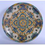 A MIDDLE EASTERN PERSIAN FAIENCE POTTERY DISH painted with foliage and scrolls. 24.5 cm diameter.
